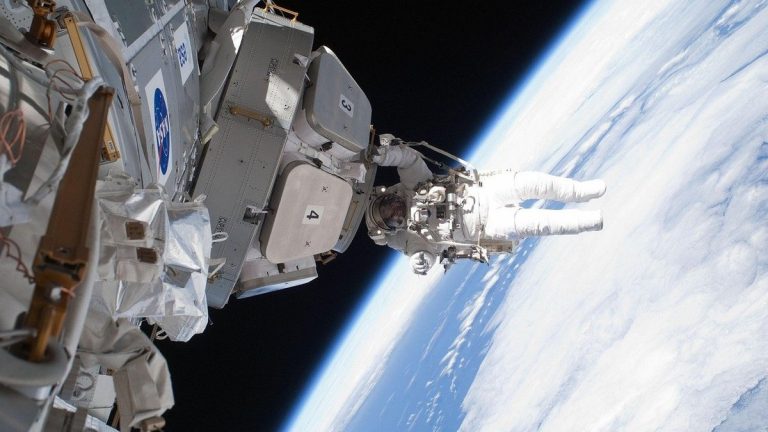 An astronaut working outside the International Space Station above Earth