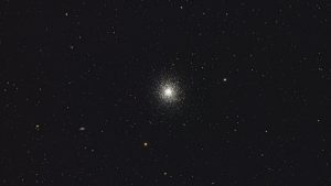 A beautiful capture of a distant globular star cluster set against a night sky backdrop, showcasing the cosmos