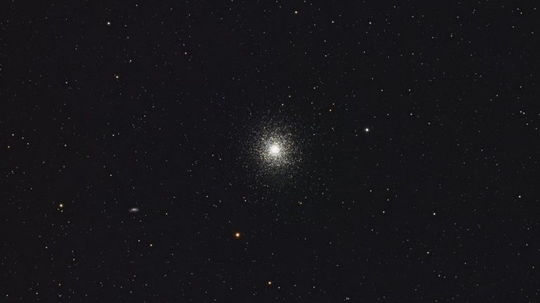 A beautiful capture of a distant globular star cluster set against a night sky backdrop, showcasing the cosmos