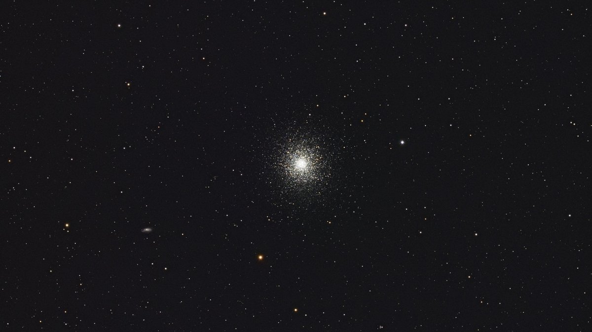 A beautiful capture of a distant globular star cluster set against a night sky backdrop, showcasing the cosmos