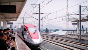A modern high-speed passenger train arriving at a railway station
