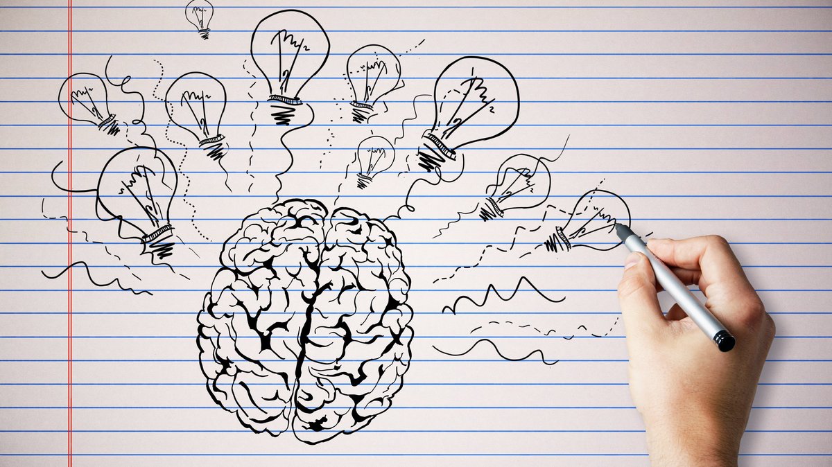 Creative hand drawn brain and light bulbs on copybook page background. Brainstorm and innovation concept