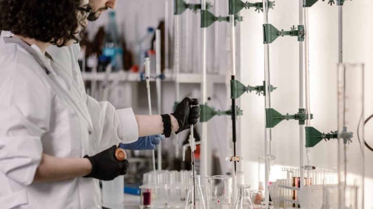 Scientists in lab coats work with test tubes in a modern laboratory