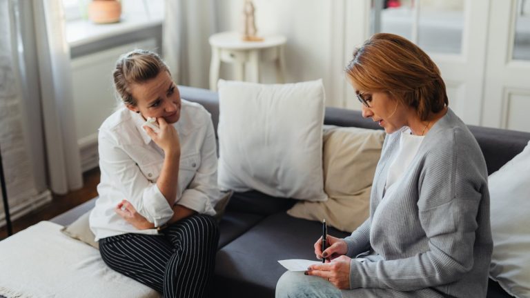 Two women speaking during a counseling session in a quiet room