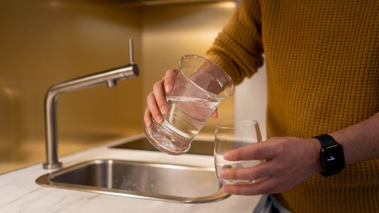 Water being poured from a pitcher into a drinking glass