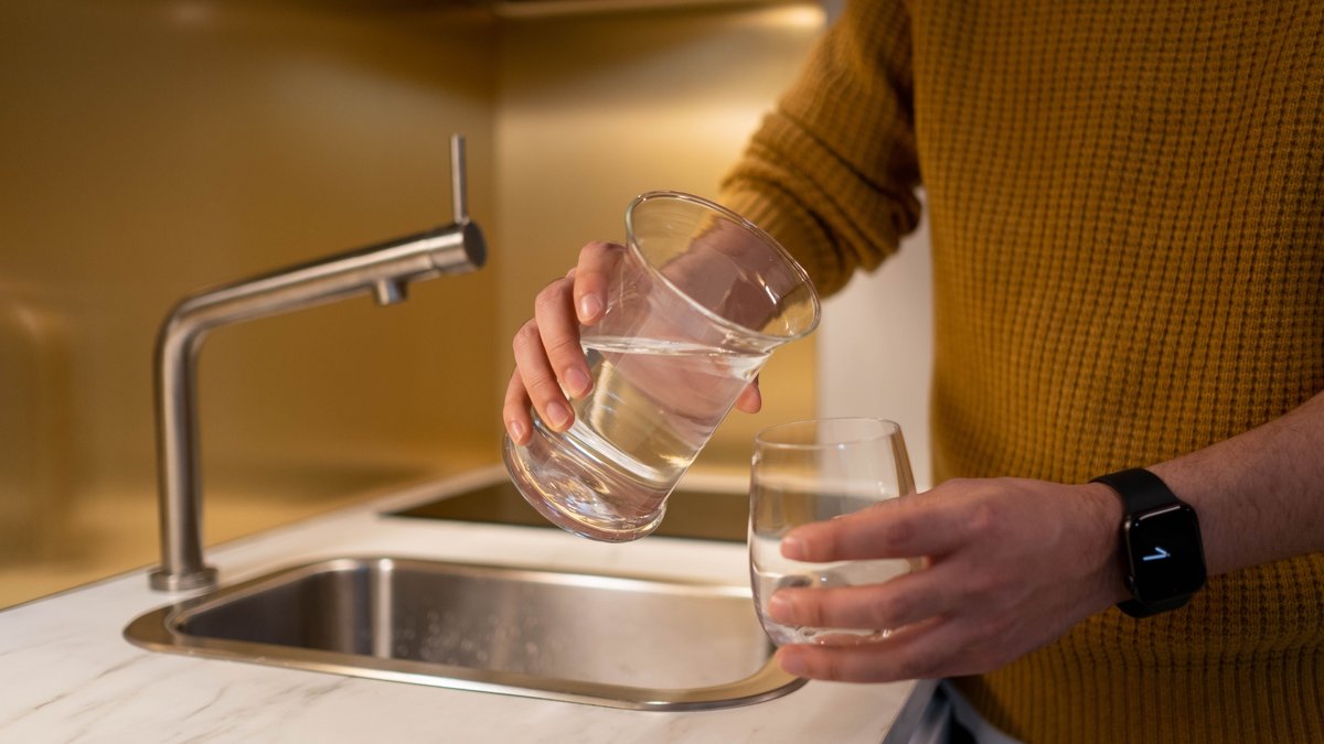 Water being poured from a pitcher into a drinking glass