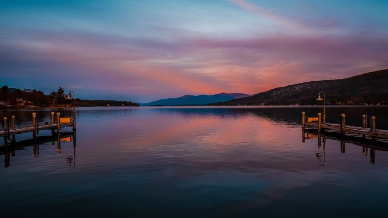 Wooden docks on Lake George beneath a colorful sunset