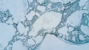 Stunning aerial shot of icy arctic landscape showcasing floating ice and calm winter sea