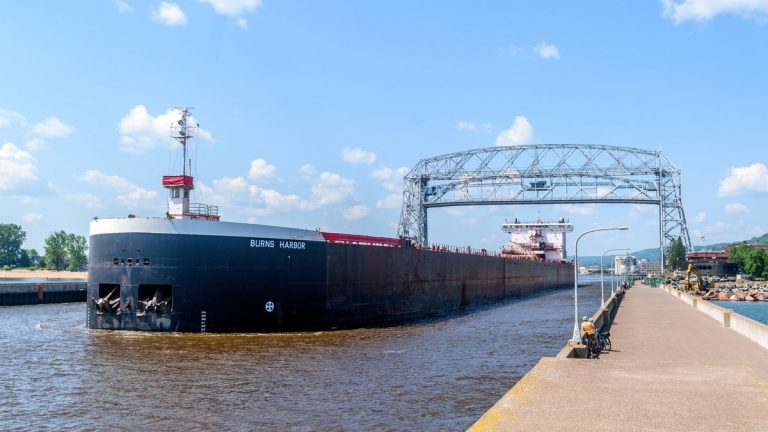 Cargo ship passing beneath the Aerial Lift Bridge on the Great Lakes waterway at Duluth