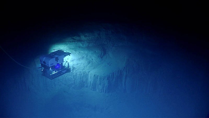 Remotely operated vehicle Deep Discoverer surveys an interesting geological feature during the final dive of the Windows to the Deep 2018 expedition. Image courtesy of NOAA Office of Ocean Exploration and Research. Download image (jpg, 36 KB) .