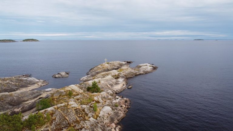 Aerial view of a tranquil rocky island in Lake Ladoga, Karelia, Russia under a blue sky