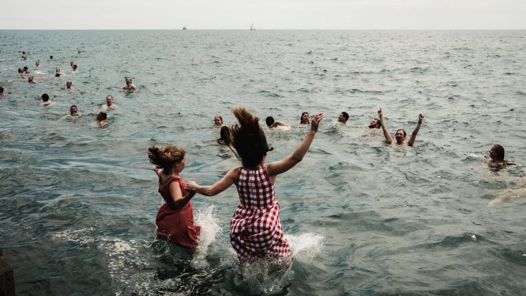 Children and adults swimming in Lake Michigan on a summer day