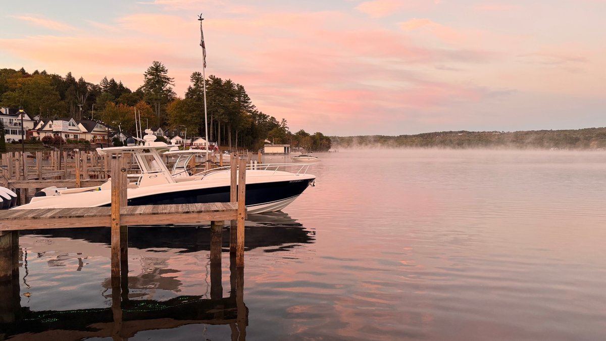 Calm waters and boats at sunset on Lake Winnipesaukee offer a tranquil scene