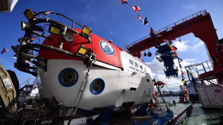 A close-up view of a submarine on a dock, under a clear blue sky