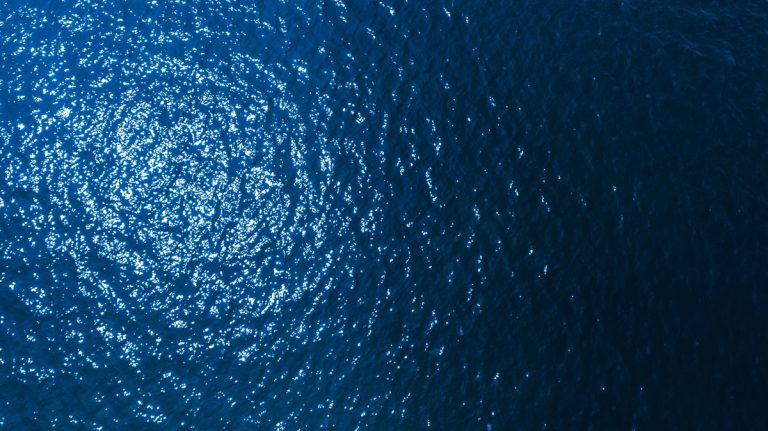 Aerial top view of blue sea surface