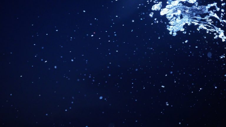 Water splash on dark blue like deep ocean background for abstract water concept