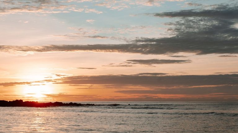 Peaceful ocean view at sunrise with a warm golden horizon and tranquil sea