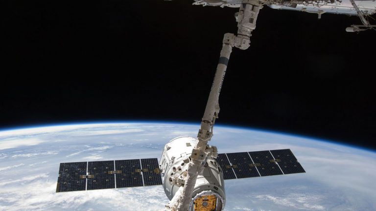 A spacecraft docked at the International Space Station above Earth