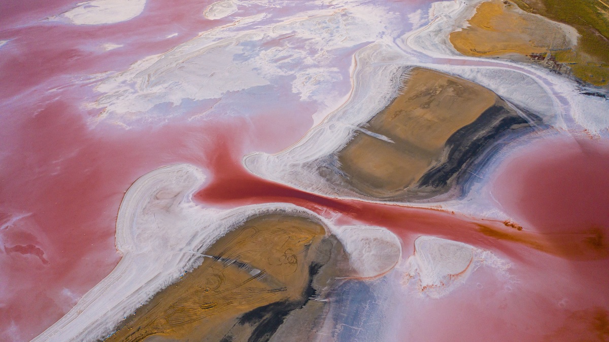 Stunning aerial view of a vibrant pink salt lake landscape with unique formations, creating a mesmerizing natural wonder