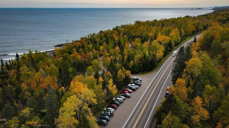 A road following the forested Lake Superior shoreline in autumn