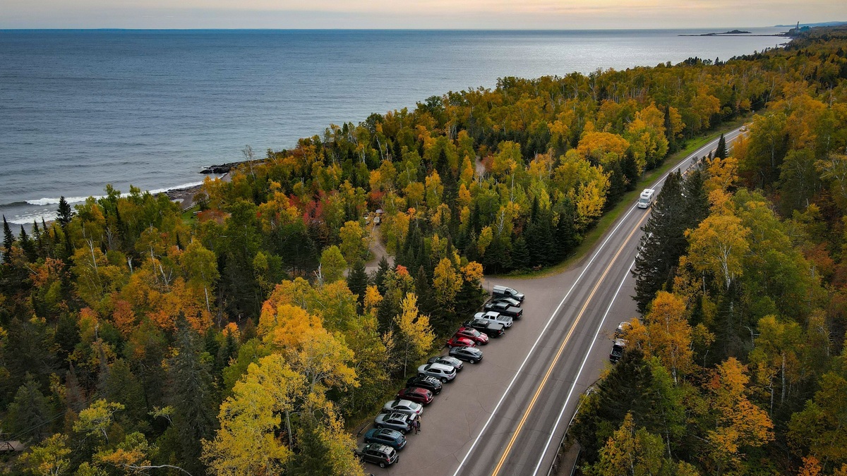 A road following the forested Lake Superior shoreline in autumn