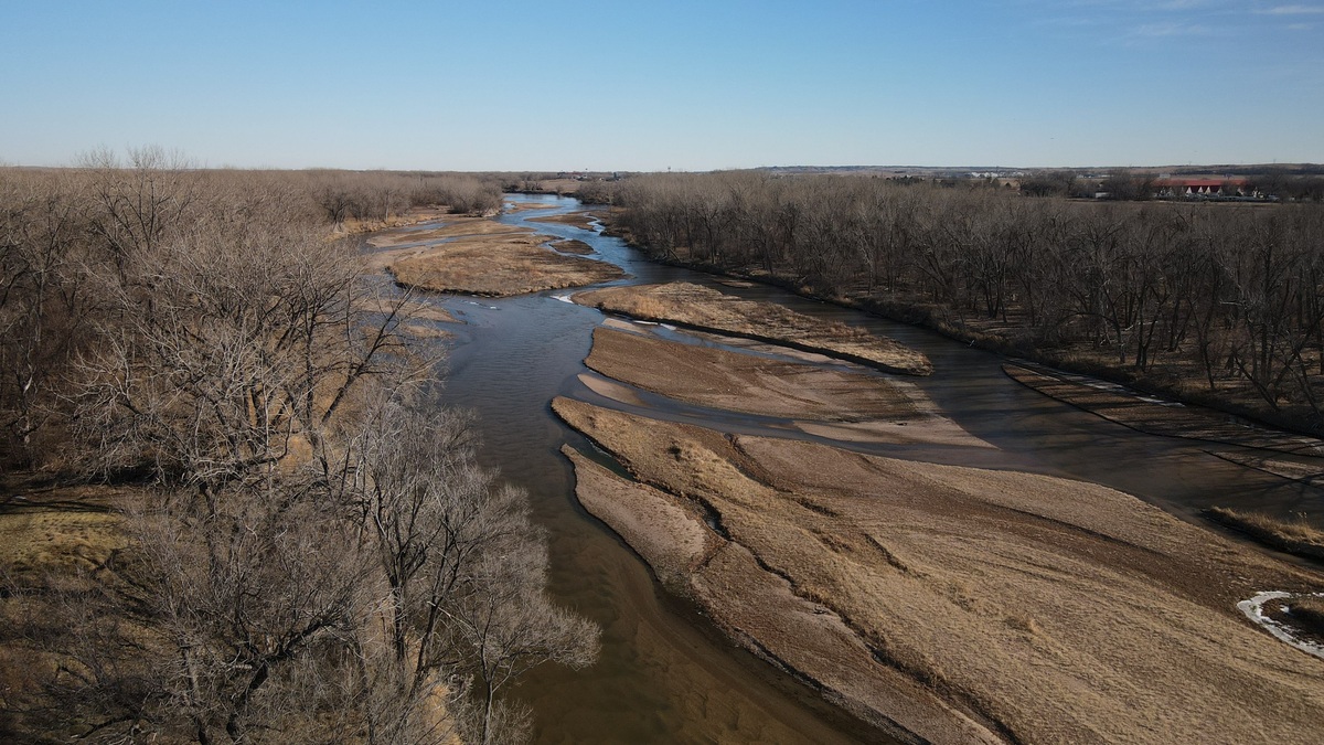Aerial view of winding North Platte River with sandbanks in a sunlit winter landscape