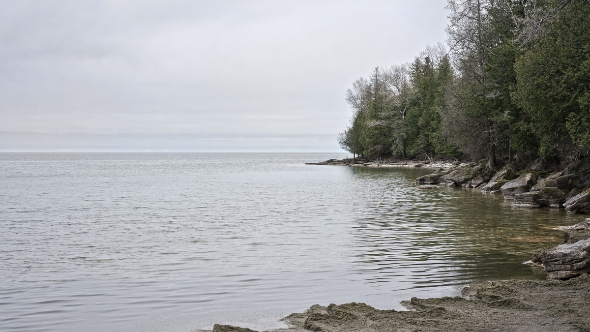 Peaceful view of Lake Michigan's shore in Wisconsin with calm waters and rocky landscape