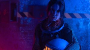 Portrait of a female astronaut with helmet under blue and red lights, exploring themes of space and technology
