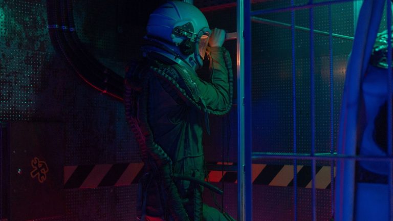 Astronaut in a futuristic setting wearing a space suit, exploring a lit indoor environment