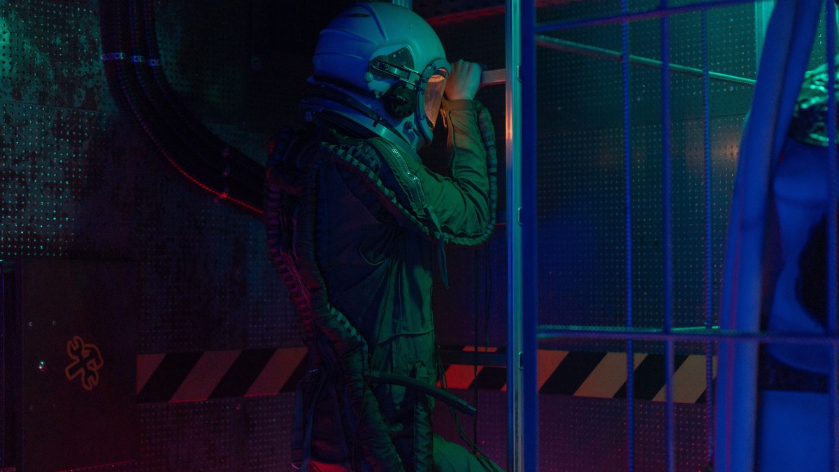 Astronaut in a futuristic setting wearing a space suit, exploring a lit indoor environment