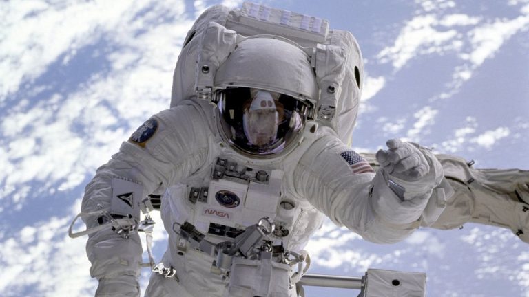 Astronaut conducting a spacewalk with Earth in the background, showcasing outer space exploration