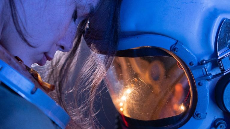 A woman in a space helmet during a reflective moment
