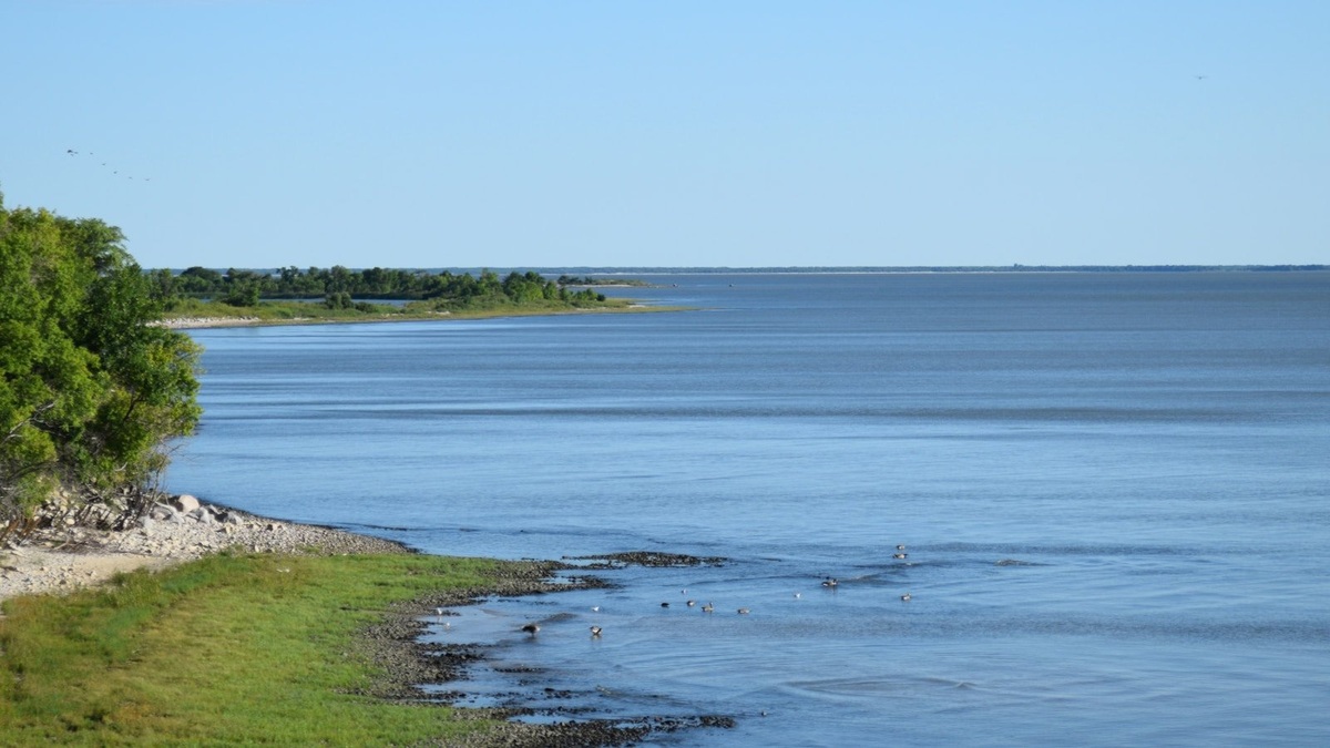 Broad_lake_and_grassy_shore_in_manitoba