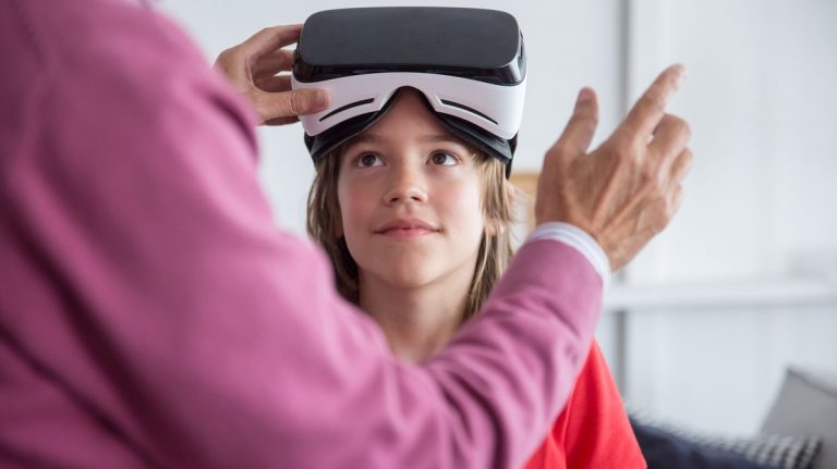 A child trying a virtual reality headset with guidance