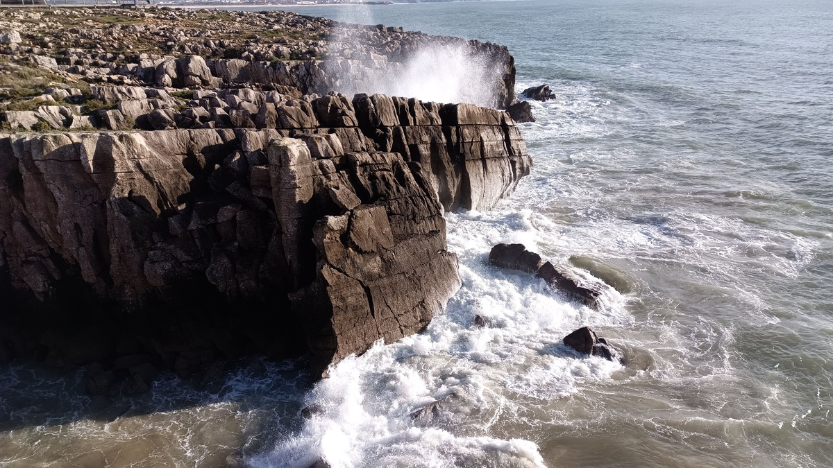 Powerful ocean waves crash into the rugged cliffs of Peniche, Portugal, creating a breathtaking coastal view