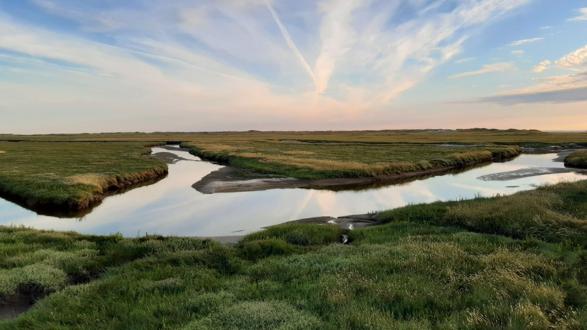 Beautiful salt marsh reflecting the sky during sunset at Sankt Peter-Ording, Germany