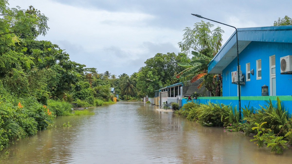 A tropical street in Nolhivaranfaru, Maldives, submerged due to flooding