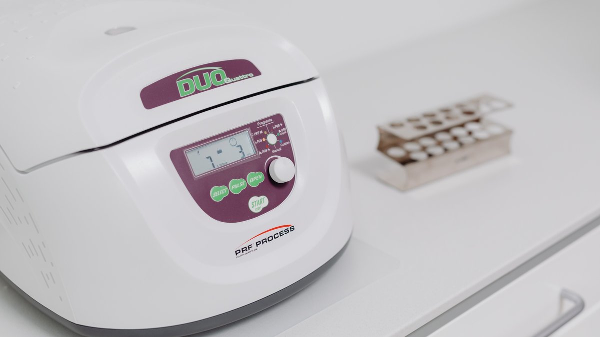 Close-up of a modern laboratory centrifuge on a sterile white surface, used in medical testing