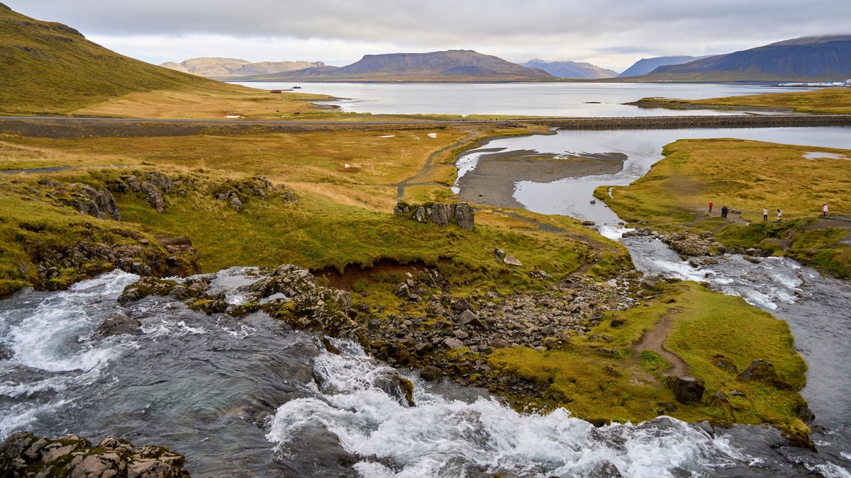 A breathtaking aerial view of a pristine Icelandic landscape featuring a flowing river and serene lake