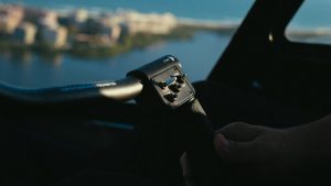 A person's hand gripping an aircraft control inside a cockpit during daytime