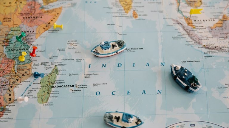 Detailed world map featuring toy ships and colored pins plotted over the Indian Ocean