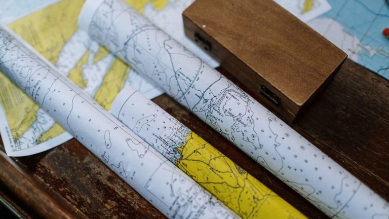 Close-up of rolled nautical maps on a wooden table, perfect for navigation themes