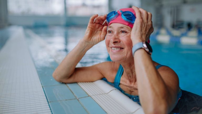 Older swimmer wearing goggles at a pool