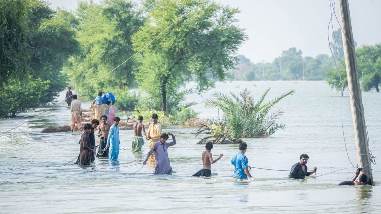 People wading through dangerous moving water