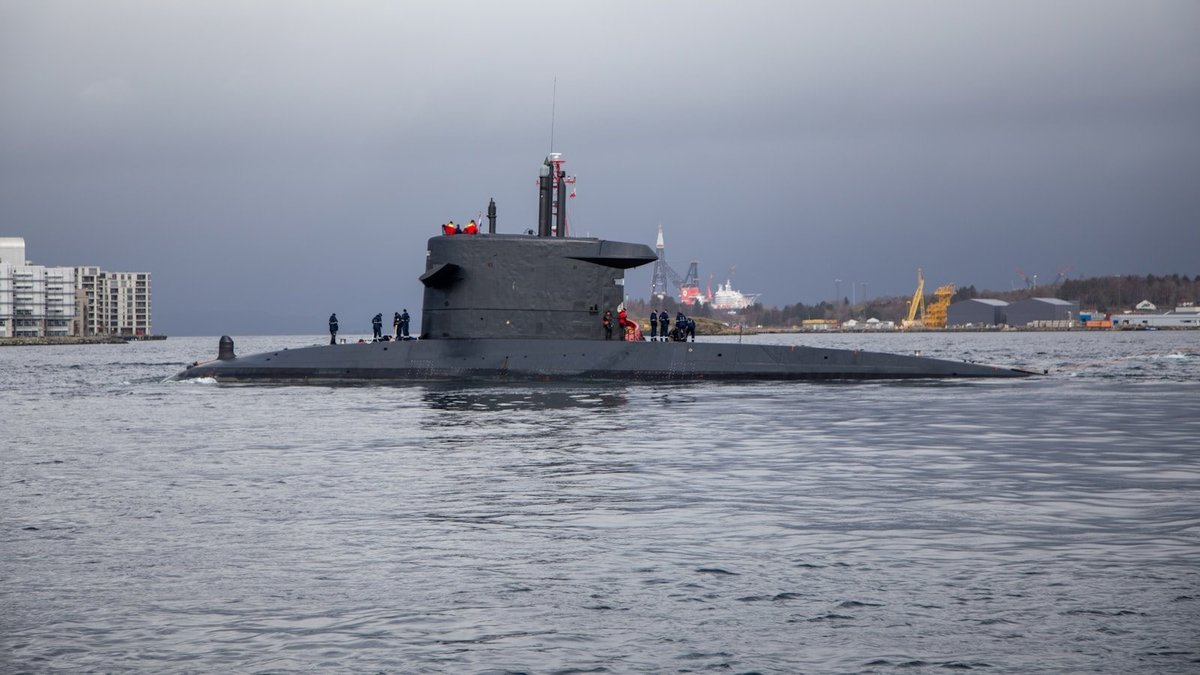 A submarine traveling at the ocean surface with crew members on deck
