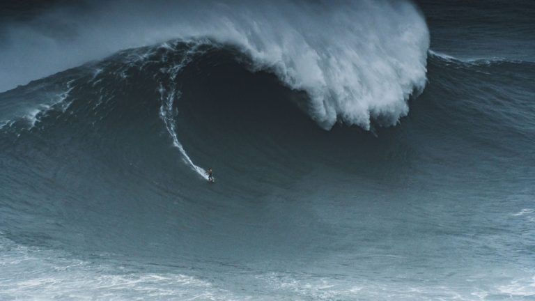 Surfer_below_a_giant_ocean_wave