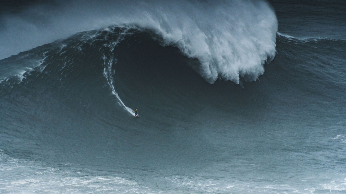 Surfer_below_a_giant_ocean_wave