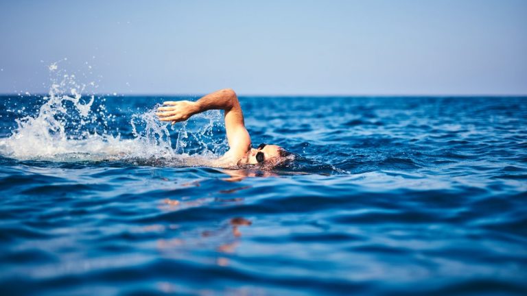 Swimmer training on the open sea / ocean