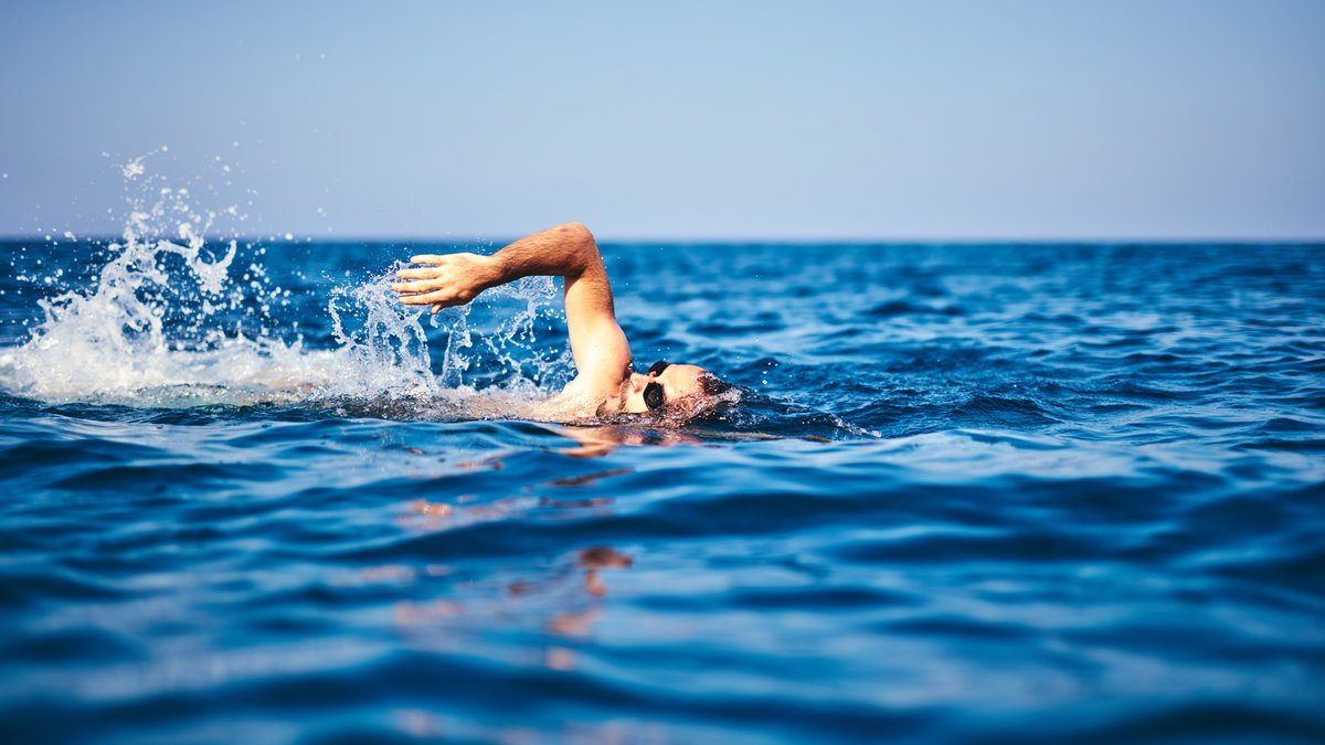 Swimmer training on the open sea / ocean