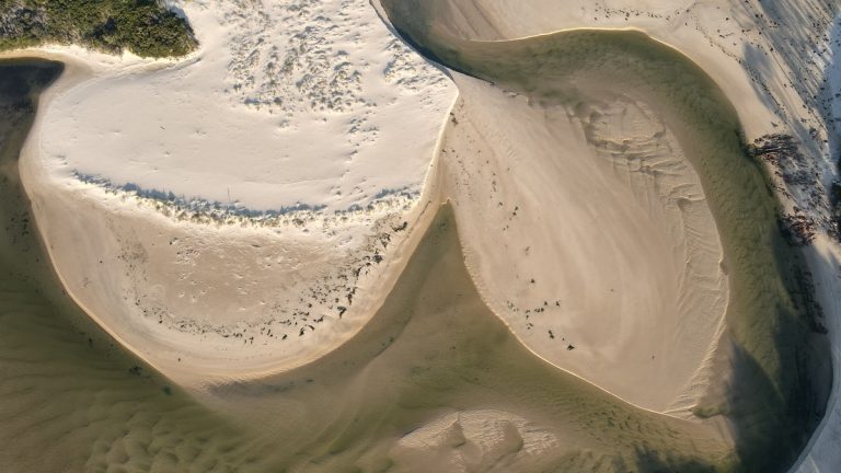 Drone aerial shot capturing unique patterns of sand and water at a coastal area in Victoria, Australia
